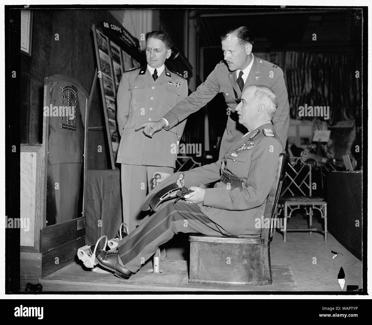 Tester Aviator's Zeigen an den Militärischen Ärzte und Apotheker Kongress. Washington, D.C., Mai 8. Lieut. Ugo Reitano, Army medical corps Mitglied aus Italien, Kapitän C.L. Leedhorn der amerikanischen Schule der Luftfahrt, auf schauen, während allgemeine Konstantin Iliescu, der Rumänien heraus versucht die neuesten US-Armee mechanische Tester für Reaktion der Piloten. Die Maschine stellt theoretische Probleme für den Piloten und seine Reaktion auf jeden Test, dadurch entfällt der aufwändige Tests durch andere Methoden Stockfoto