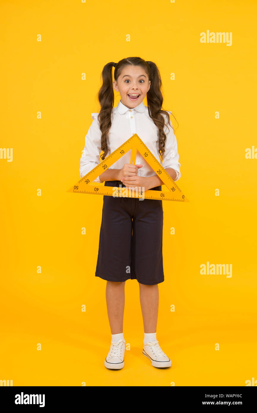 Messgeräte. Kid cute Schüler studieren Mathematik. Dreieck rechten Winkel. Kenntnisse täglich. Schulmädchen Uniform halten große Herrscher Geometrie Schule Lektion. Mathe Stammzellen Fachbereich Architektur. Stockfoto