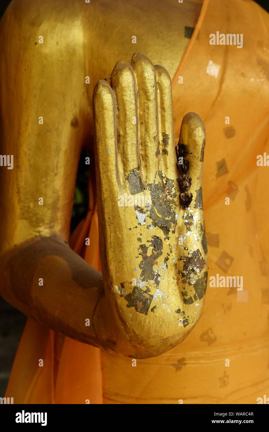 Hand des Buddha goldene Statue gelbe Robe bekleidet schlafen, Skulptur als Amulette des Buddhismus Religion, religiöse Identität in der asiatischen Kultur, Thailand Stockfoto
