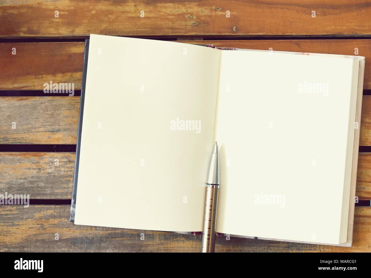 Stift und Buch auf leere Seiten auf alte braune Holzvertäfelung, Platz auf der Seite für Bilder oder Text Stockfoto