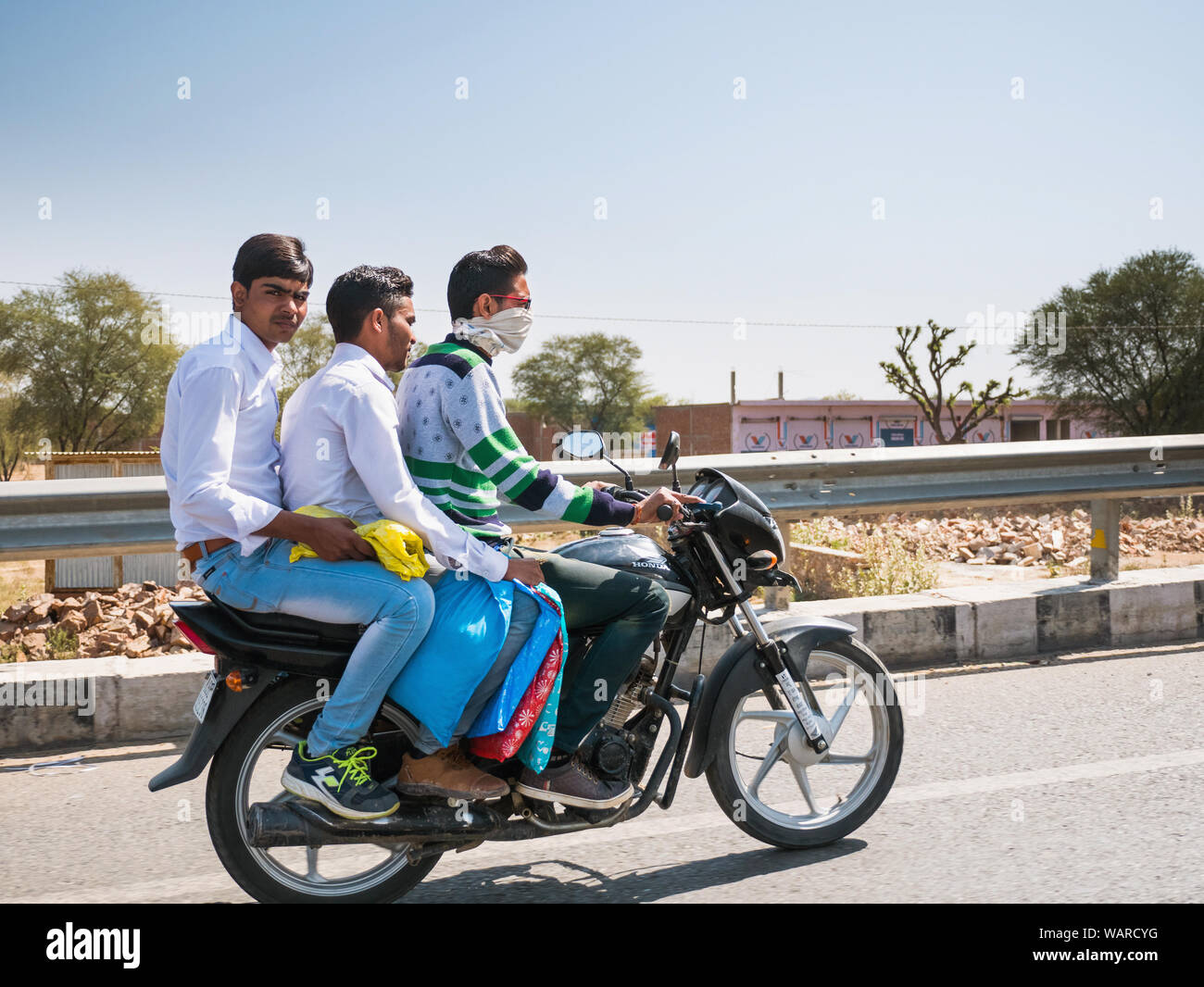 Drei Freunde teilen ein Motorrad auf den Straßen außerhalb von Neu Delhi, Indien Stockfoto