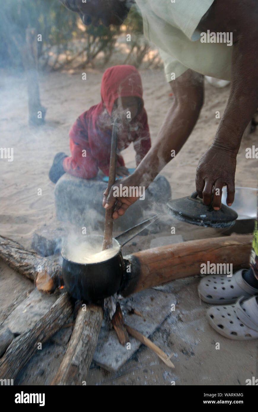 Alte Dame kochen eine Kanne Nshima, einem dicken Brei aus fein gemahlenen Maismehl, Mwandi, Sambia, Afrika. Stockfoto