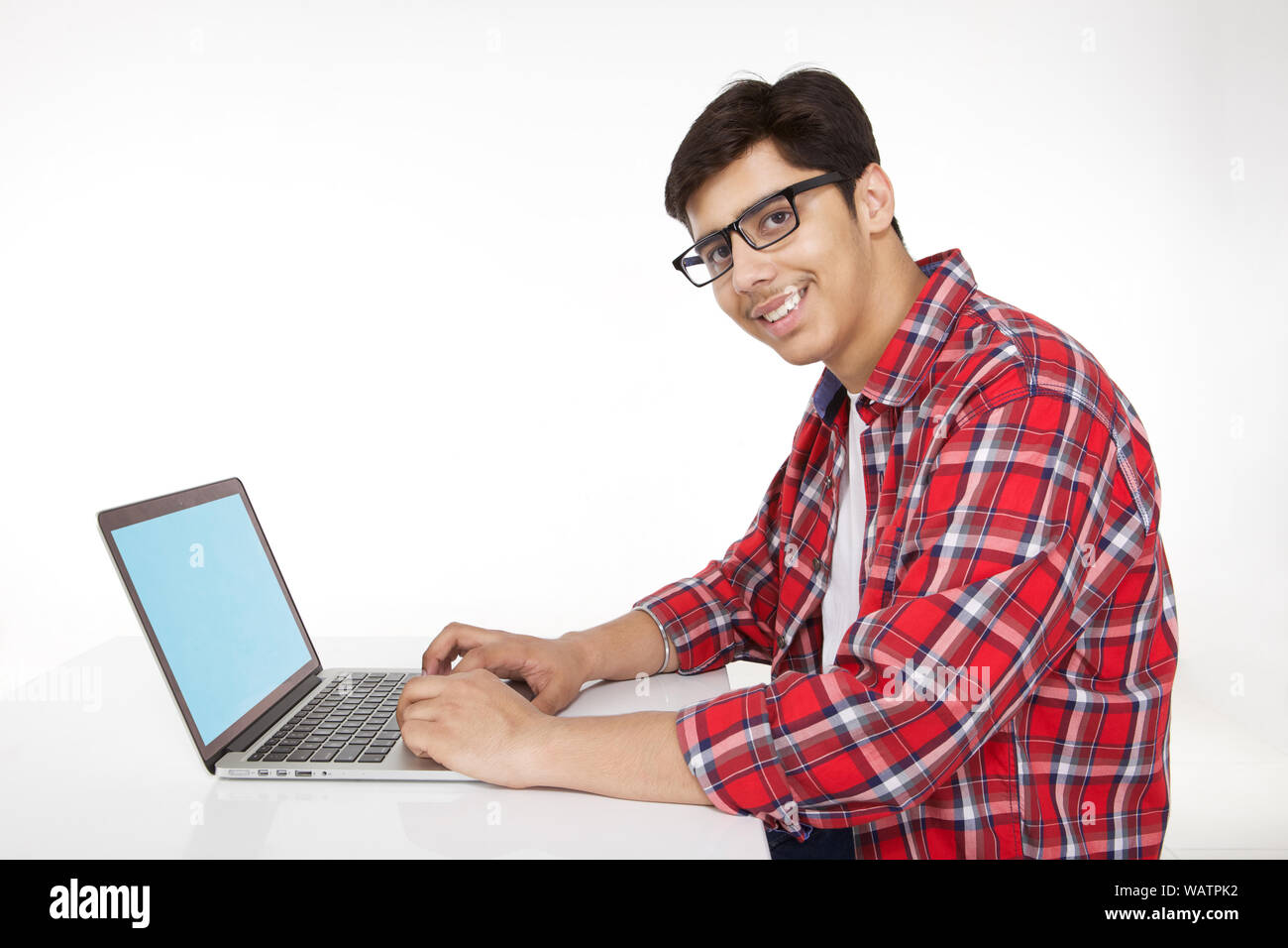 College-Student arbeitet an einem Laptop und lächelt Stockfoto