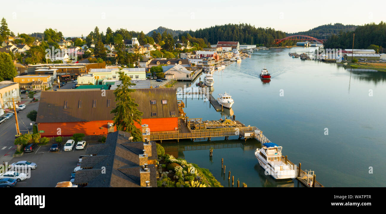 Am späten Nachmittag Sonnenlicht schlägt die Waterfront als rotes Boot passiert vor La Conner Washington Stockfoto