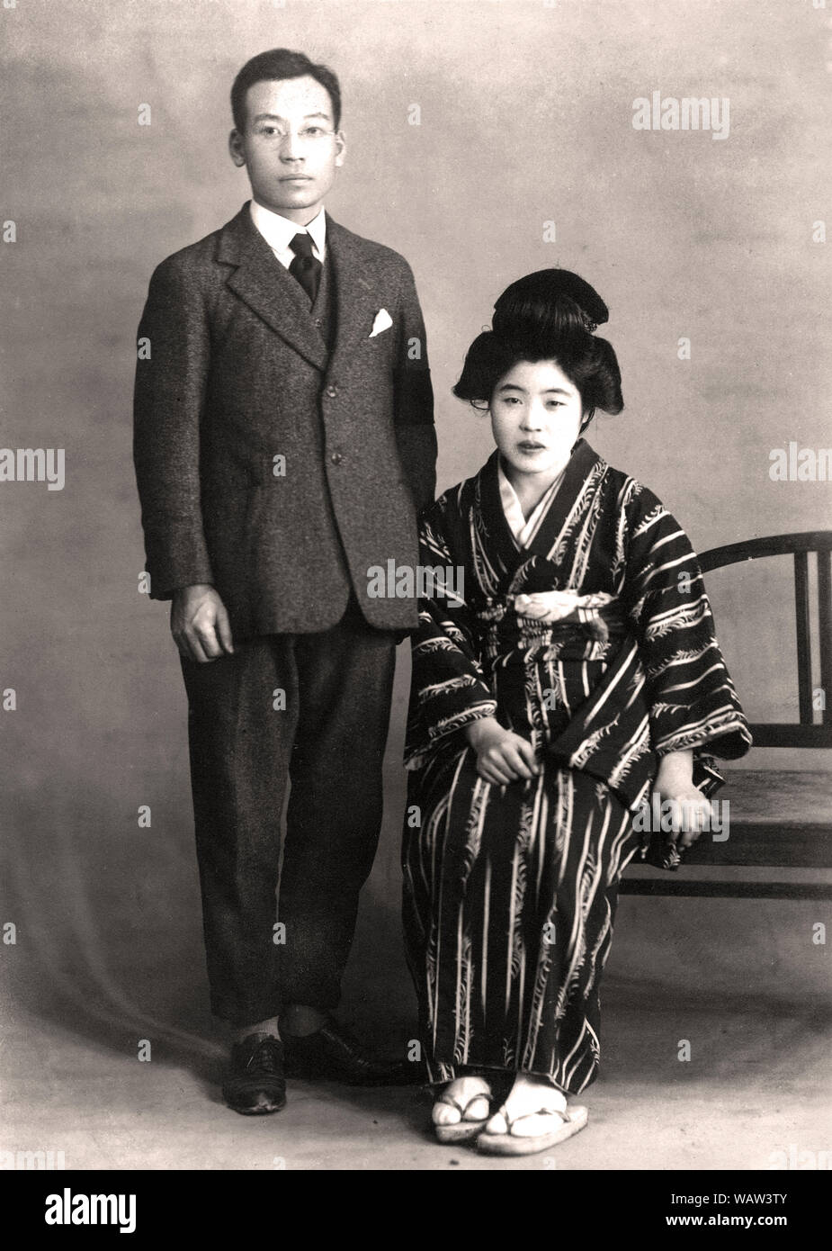 [1920s Japan - jungen japanischen Paar] - jungen japanischen Paar. Der 33 Jahre alte Mann trägt einen westlichen Anzug und seine 24 Jahre alte Ehefrau im traditionellen Kimono. Foto ist vom Jan 1926 (Showa 2). 20. Jahrhundert vintage Silbergelatineabzug. Stockfoto
