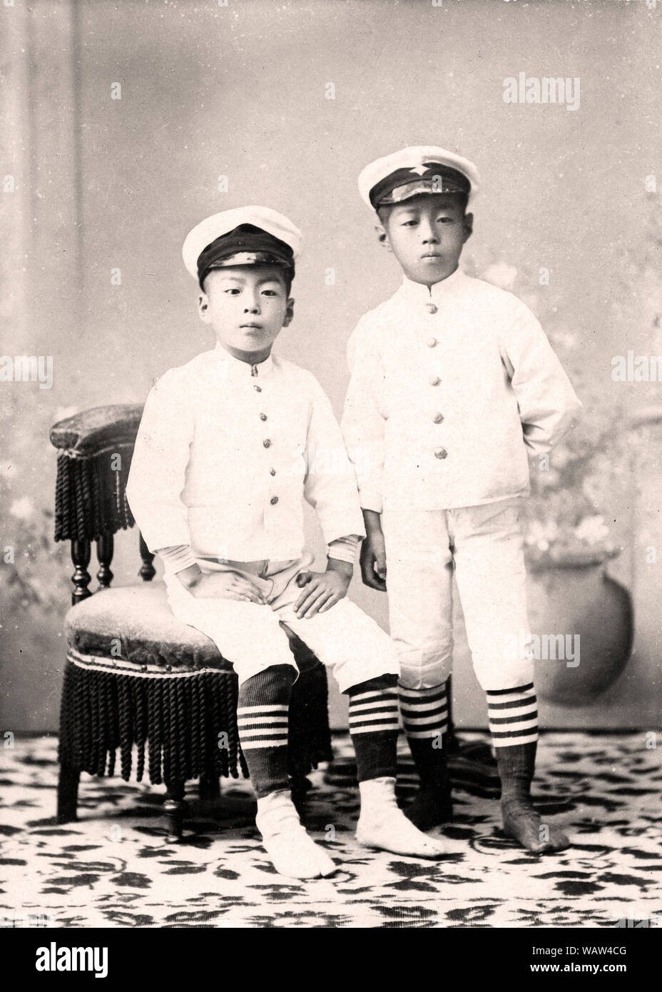 [1890s Japan - Japanische Männer in weißer Uniform] - Studio Foto von 10 und 11 Jahre alten Japanischen Brüder in Uniform. Vom 11. September 1892 (Meiji 25). 20. Jahrhundert vintage Silbergelatineabzug. Stockfoto