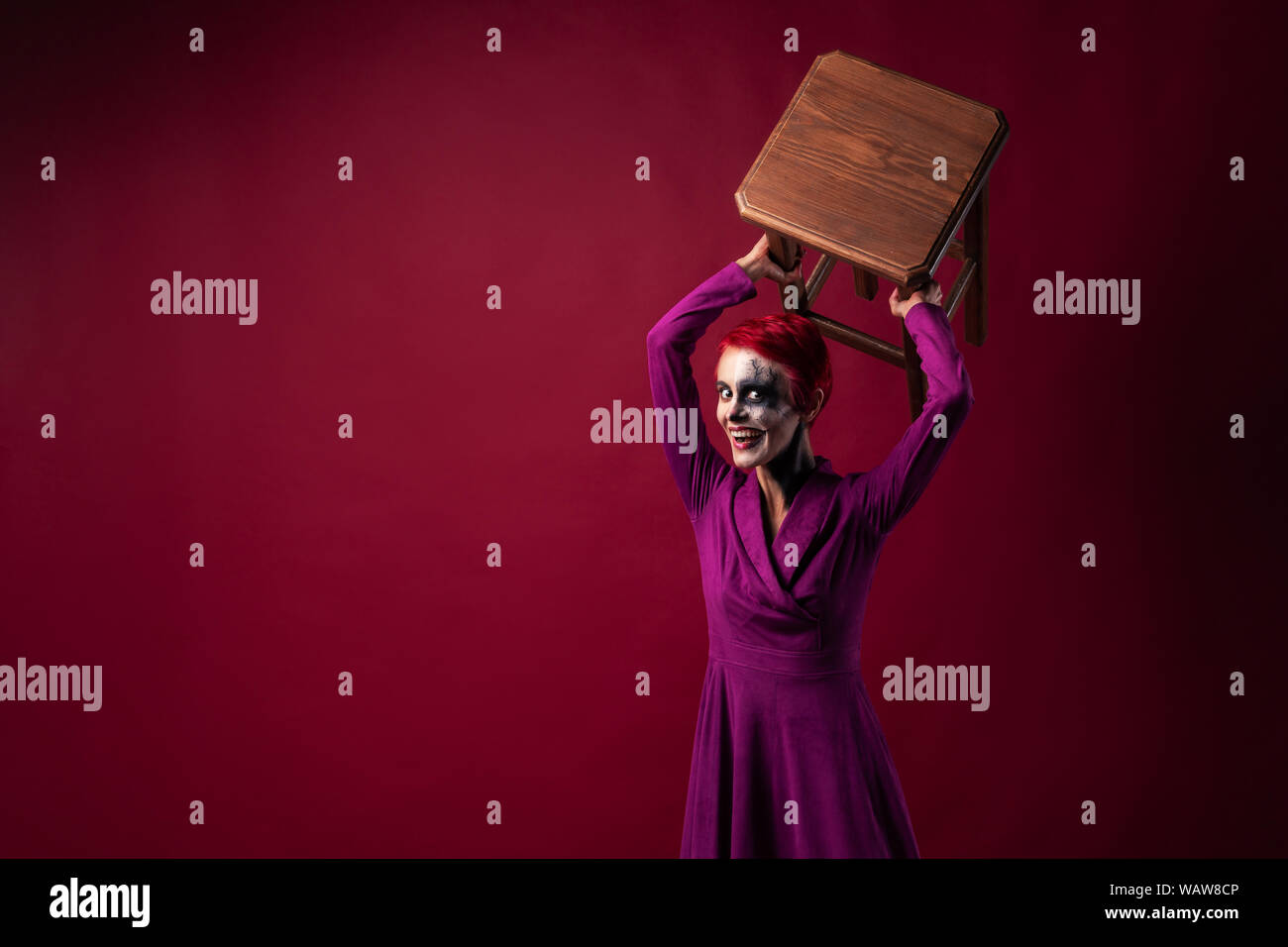 Crazy unheimlich Weiblich der Joker Wellen seinen Stuhl und lächelt Böse. Copyspace für Text Stockfoto