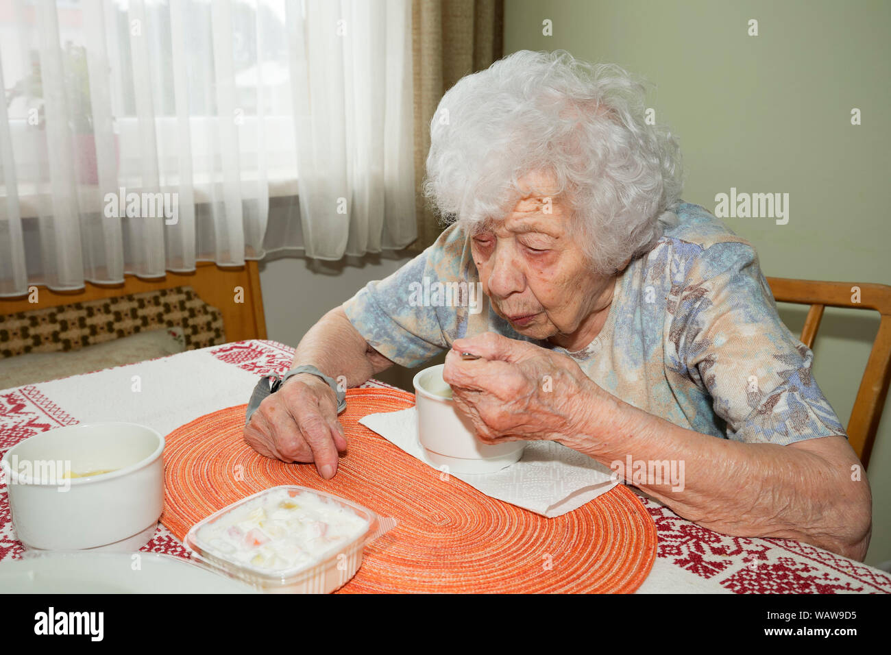 100 Jahre alte Frau am Frühstückstisch Stockfoto