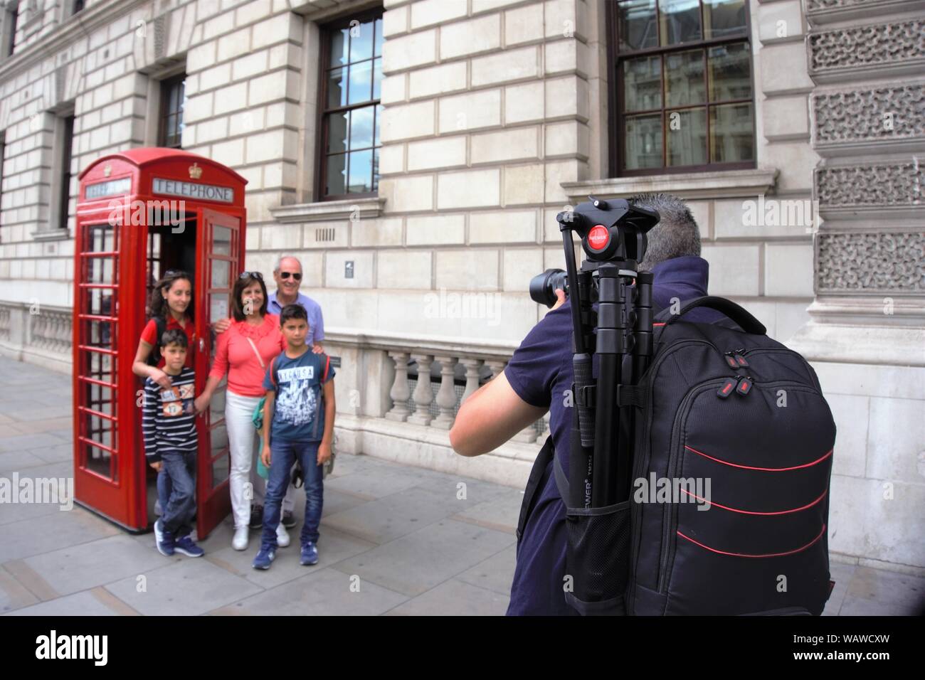 Ein Fotograf ein Bild von einer Familie vor einer roten Telefonzelle in Westminster, London, UK Stockfoto