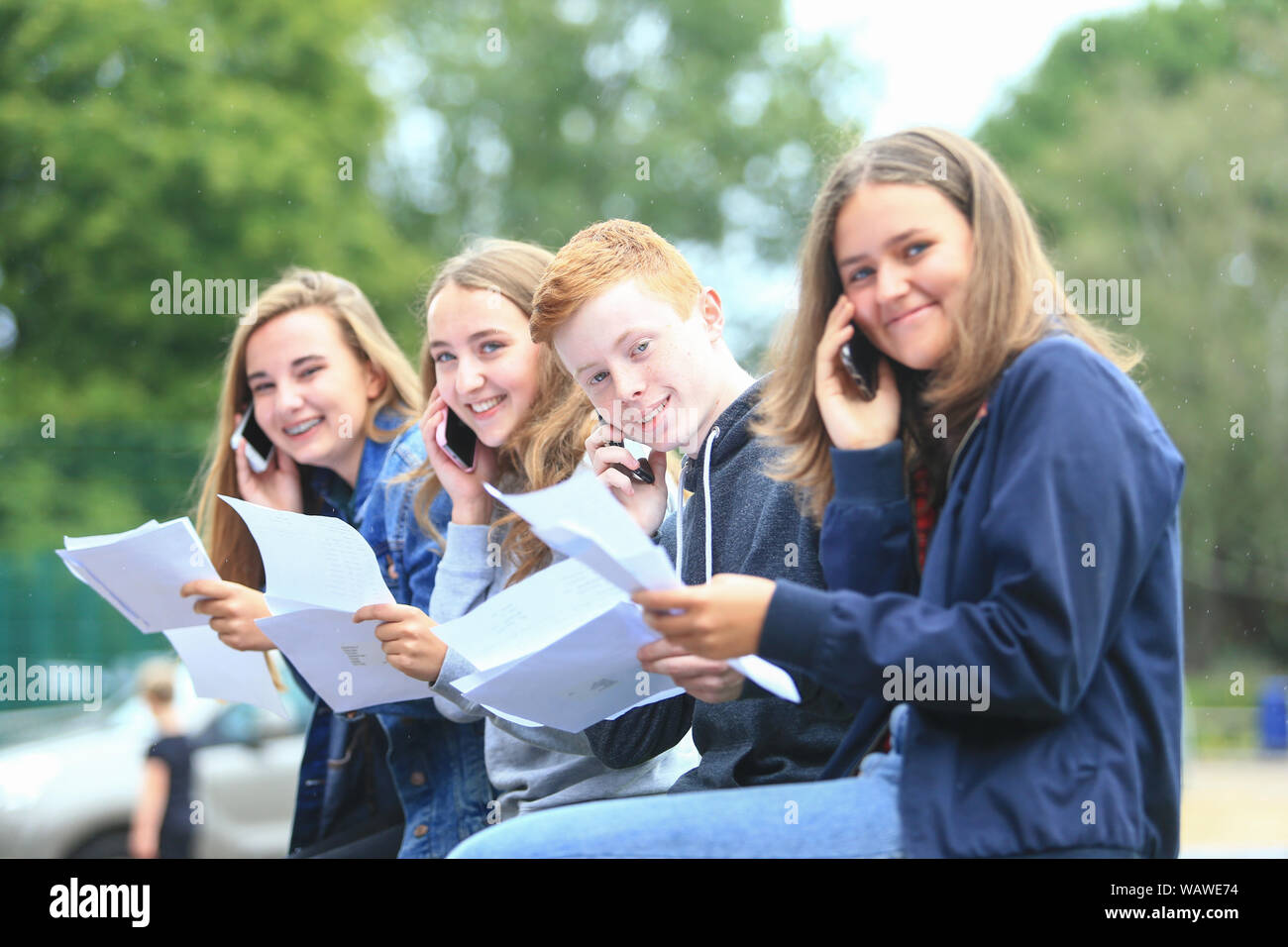 GCSE-Prüfung Ergebnisse Tag. Die Studierenden mit den Prüfungsergebnissen Buchstaben außerhalb einer weiterführenden Schule Stockfoto