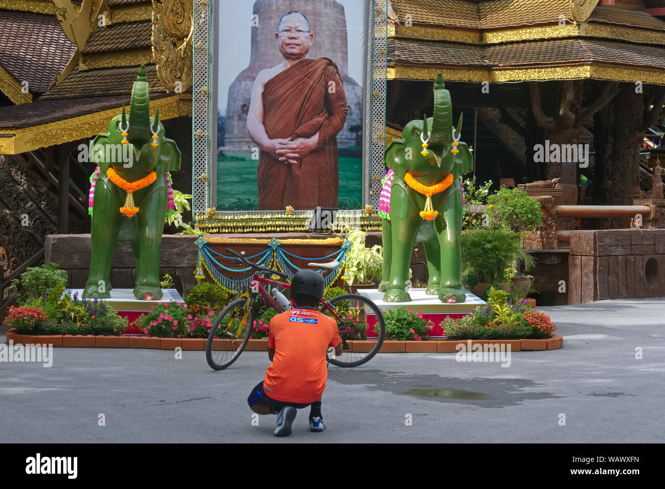 Ein Besucher in Wat Sanghathan, eine Meditation Tempel in Nonthaburi, Thailand, kniet zu Fotografieren ein Bild von Luang Phor Sanong Katapunyo, der Gründer Stockfoto