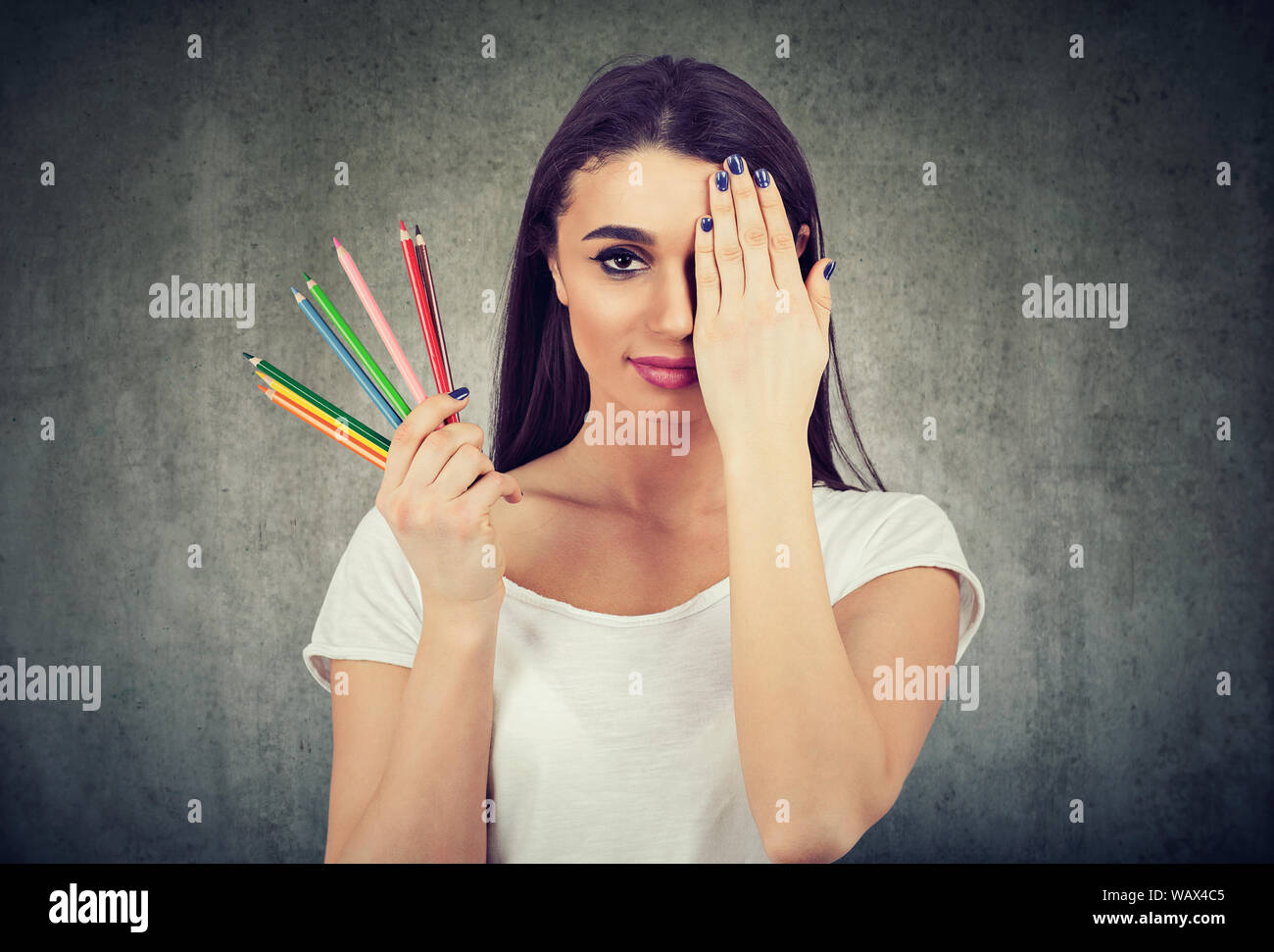 Junge Frau mit bunten Pastellkreiden auf Wand Hintergrund Stockfoto