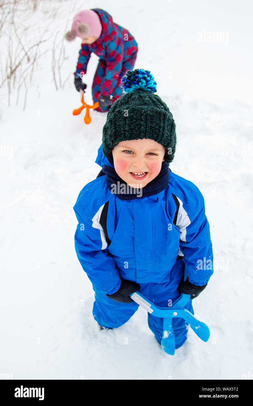 Happy Boy formt und wirft Schneebälle. Winter Spiele an der frischen Luft. Winter Urlaub. Stockfoto