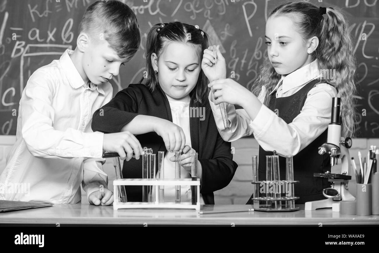 Kleine Kinder lernen die Chemie in der Schule lab. Studenten, Biologie Experimente mit Mikroskop. Tag der Kinder. Chemie. Zurück zu Schule. Kleine Kinder in der Schule Lektion. Zuversichtlich Apotheker. Stockfoto