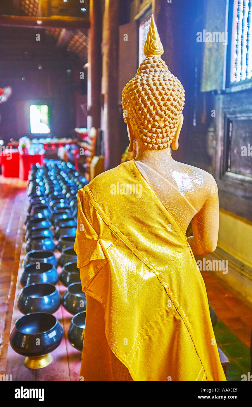 CHIANG MAI, THAILAND - Mai 2, 2019: Die Rückseite des Buddha Bild vor der Spende Schalen in dunklen Teakholz viharn (gebetsraum) von Wat Phan Tao tem Stockfoto
