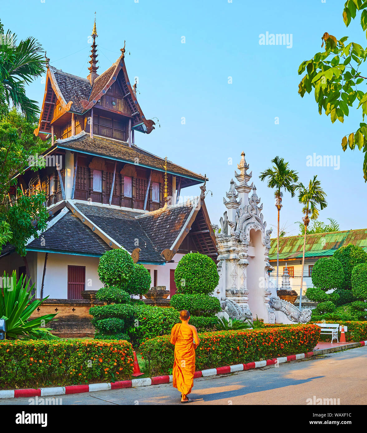 Historische Gebäude von Ho Trai (Heilige storage Texte) mit Teakholz pyathat Dach eingerichtet, geschnitzte Tor mit Mama Wächter und von Grün umgeben, Ornamen Stockfoto