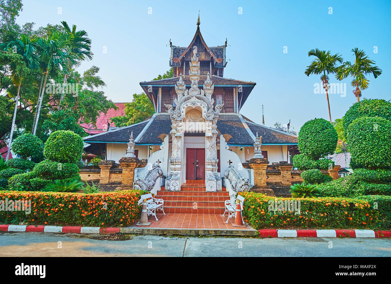 Die Fassade der Ho Trai (heilige Texte storage) und das Museum der Wat Chedi Luang mit pyathat Dach, verzierte Tor- und MOM-mythischen Wächter, umgeben von zu Stockfoto