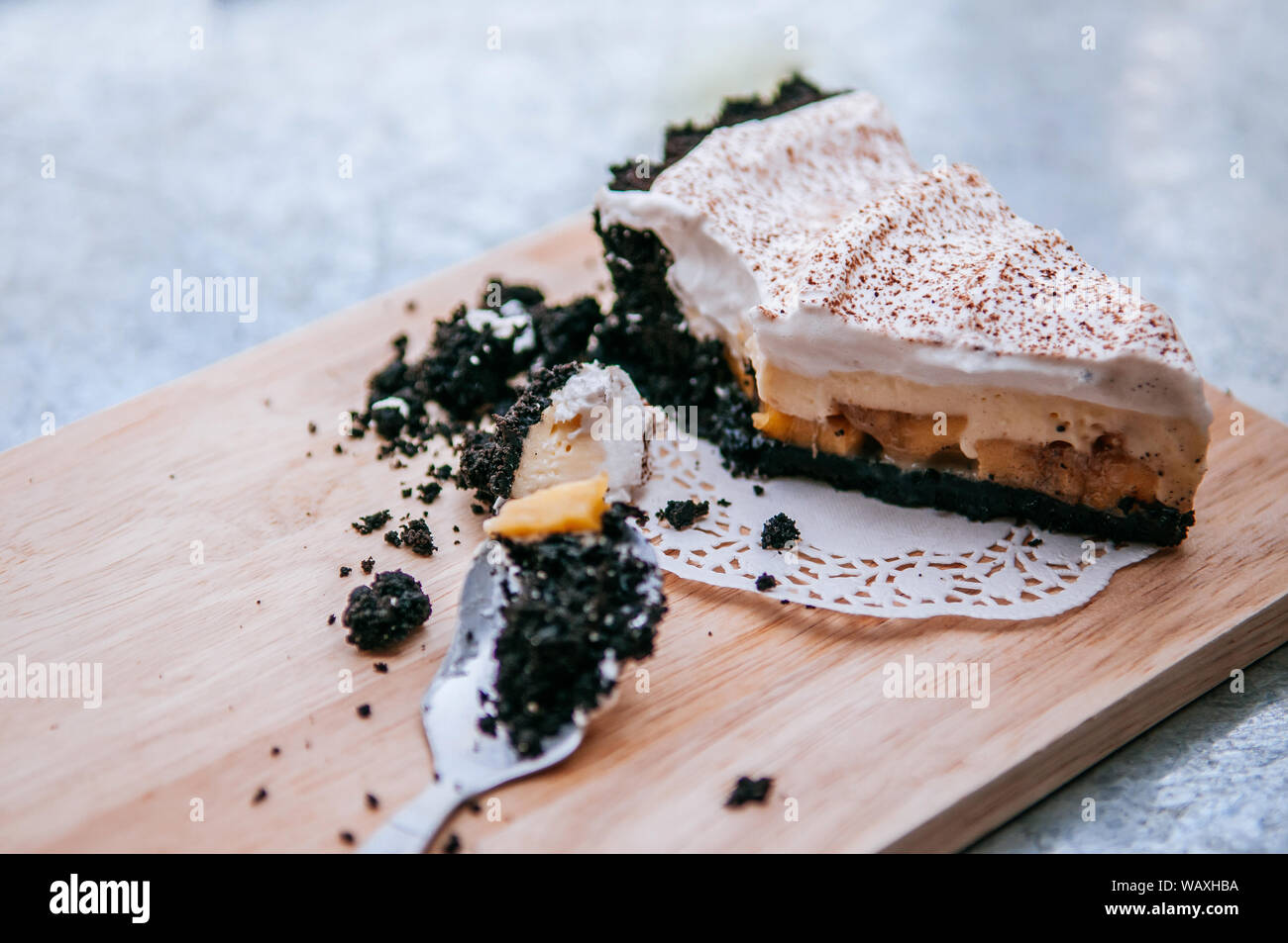 Cremige Käsekuchen Rezepte Fleisch mit Schokolade Cookies auf Holzplatte mit Löffel. Nach oben Schließen Seitenansicht Schuß Stockfoto