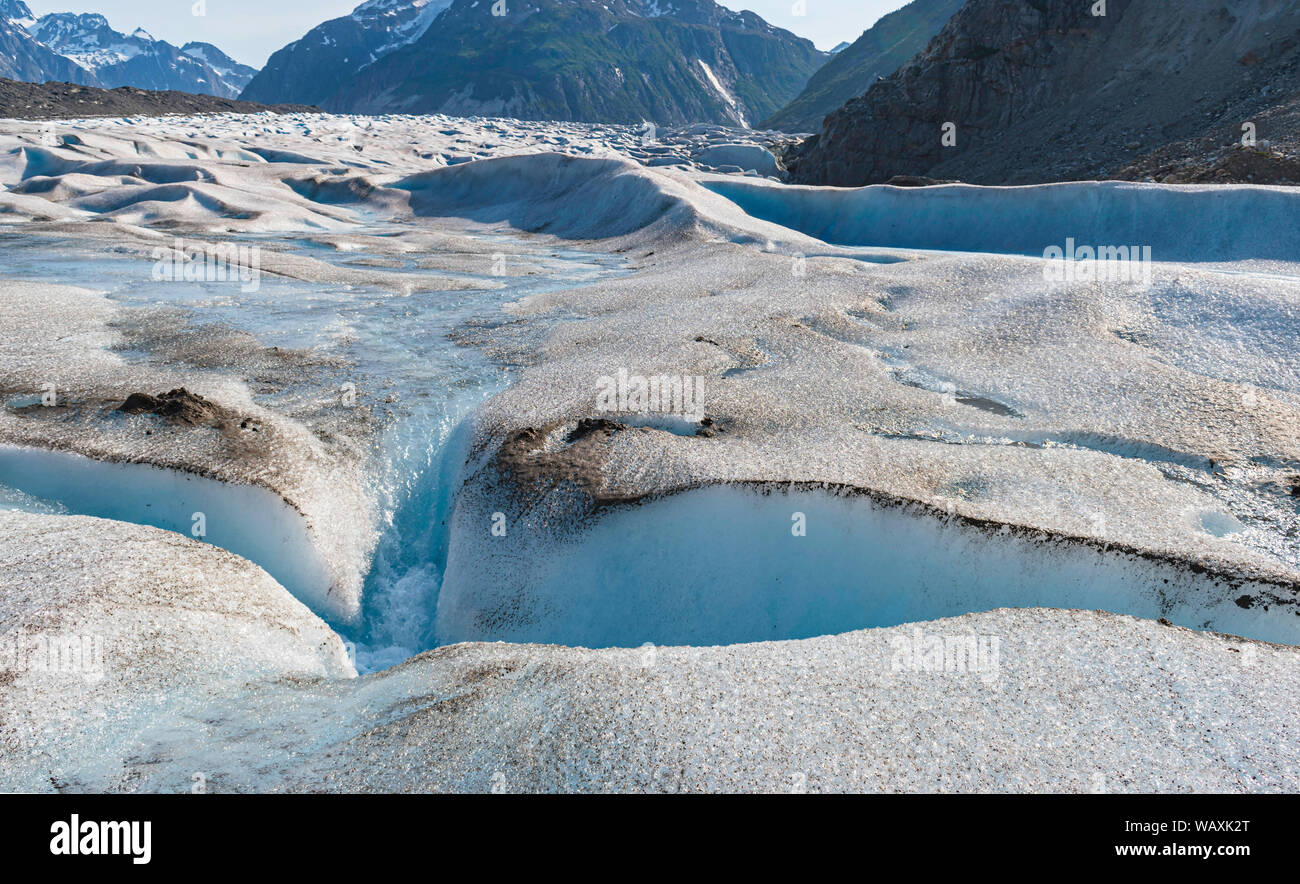 Nahaufnahme von einer Gletscherspalte in der gilkey Gletscher in Alaska mit zerklüfteten Bergen im Hintergrund Stockfoto