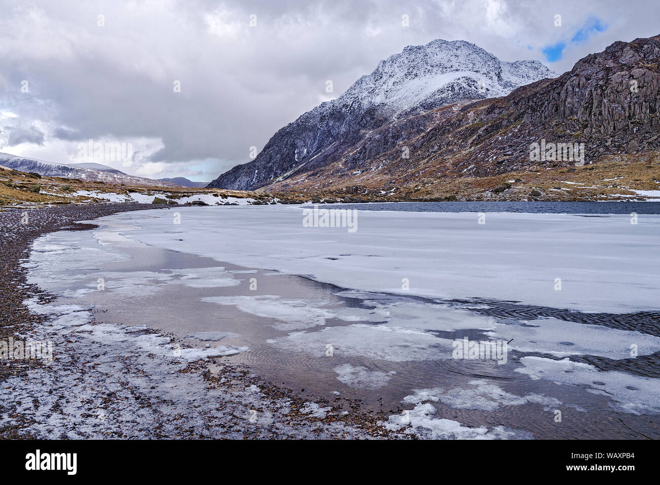 Blick nach Osten über Llyn Idwal teilweise mit Tryfan Berg im Hintergrund Snowdonia National Park North Wales UK März 2018 eingefroren Stockfoto