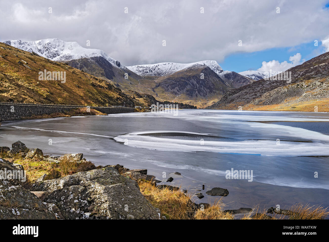 Llyn (See) Ogwen teilweise gefroren Blick nach Westen mit Y Garn Foel Goch auf der linken und auf der rechten Seite im Hintergrund Snowdonia National Park North Wales 2018 Stockfoto