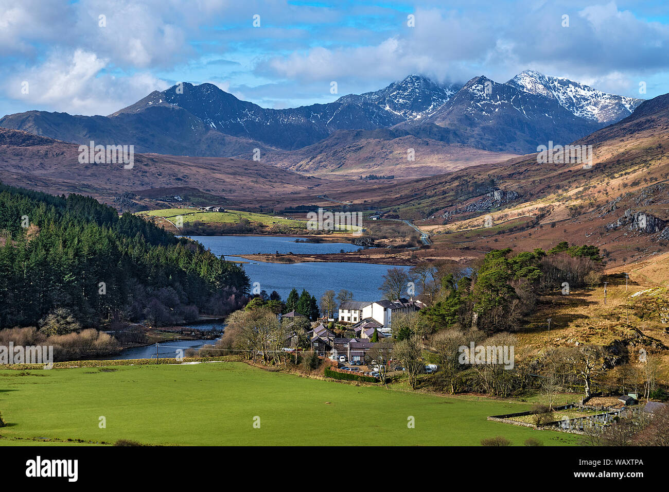Plas y Brenin National Mountain Sports Center durch Llynnau Mymbyr mit Snowdon Bergkette im Hintergrund Snowdonia National Park North Wales UK März Stockfoto