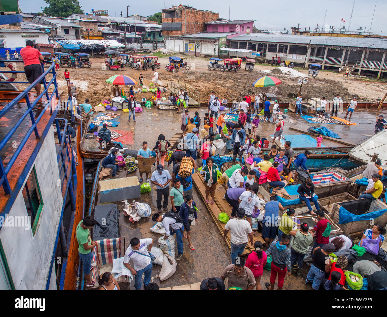 Iquitos, Peru - 14. Mai 2016: Eine Masse von Menschen vor Ort auf einem Brett cargo Schiff und einem schlammigen Küste von einem Port, über den Amazonas in Iguitos. Amazonia. S Stockfoto