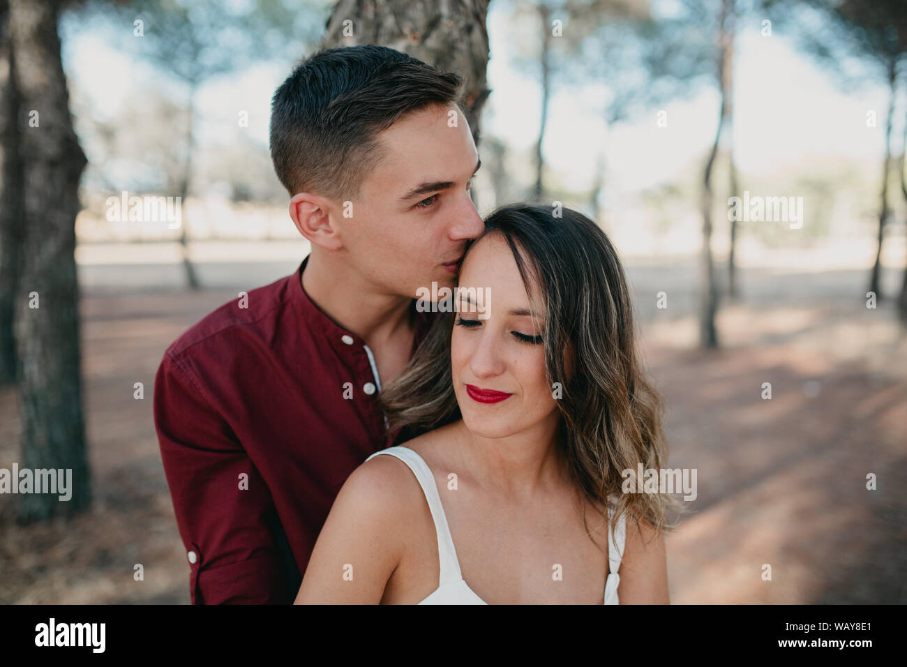 Freund küsst Freundin auf der Stirn von hinten mit Liebe Stockfoto
