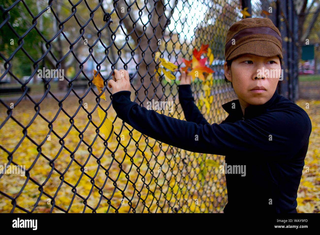Halber Baulänge sein Porträt der Frau über die Schulter beim Stehen am Zaun Stockfoto