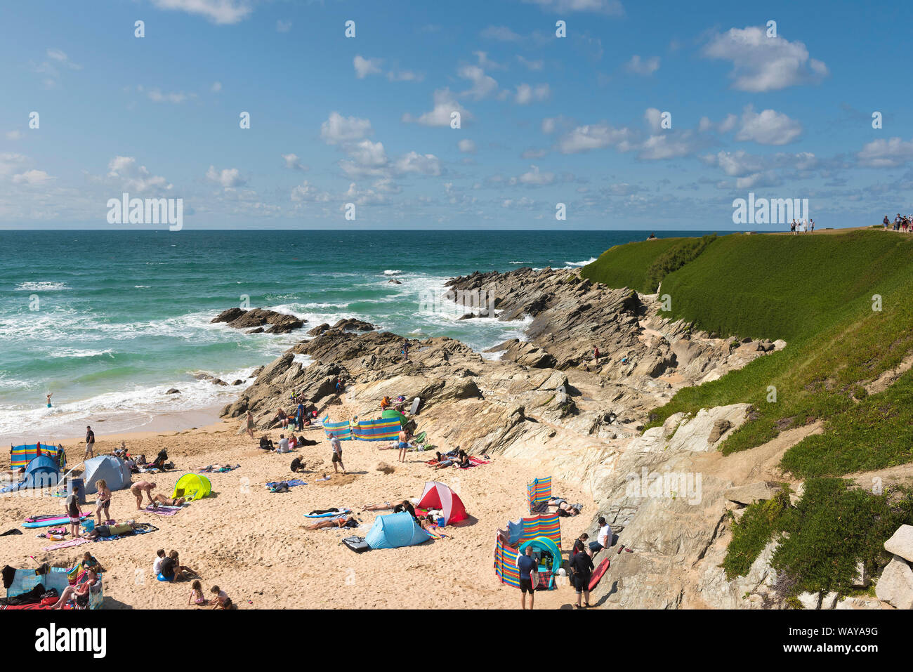 Urlauber auf einem sonnigen Fistral Beach in Newquay in Cornwall. Stockfoto