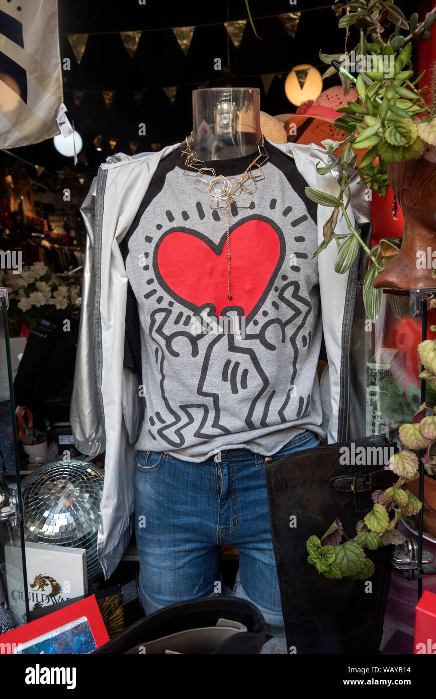 Keith Haring Herz T-Shirt im Fenster eines Charity Shop in Edinburgh, Schottland, Großbritannien. Stockfoto