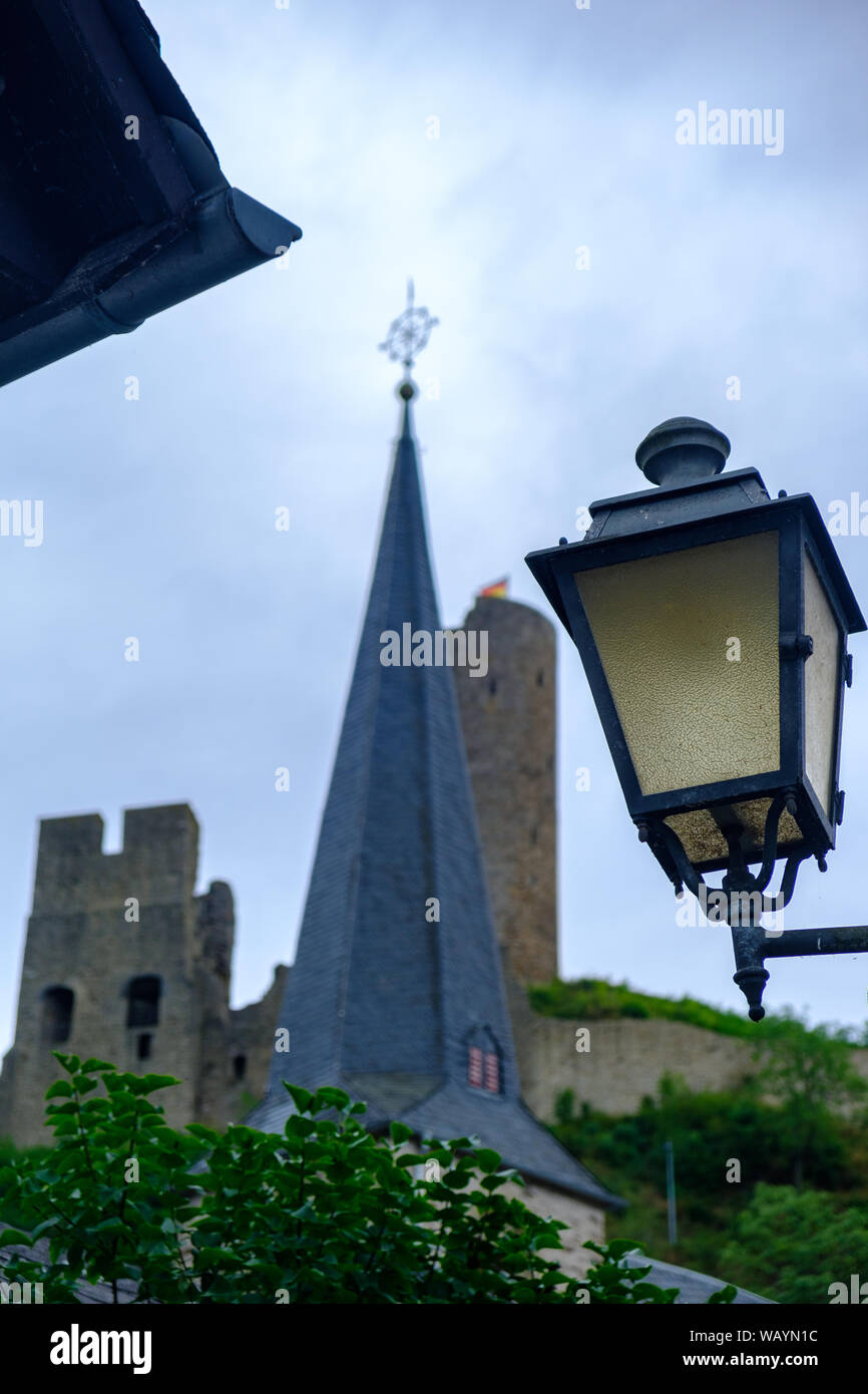 Street Light, Pfarrkirche Kirche und Löwenburg im Hintergrund das Schloss an der malerischen Ortschaft Monreal in der Eifel, Deutschland Stockfoto