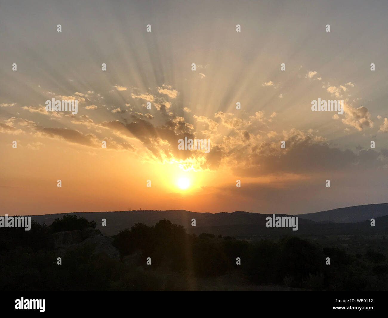 Sonnenuntergang mit Wolken und Sonnenstrahlen Stockfoto