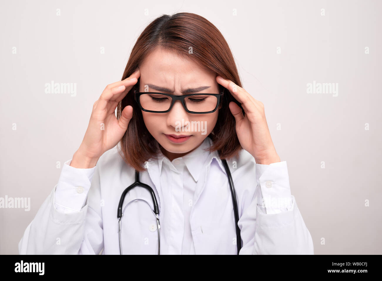 Arzt Frau mit Stethoskop problem, halten Hand Kopf auf weißem Hintergrund Stockfoto