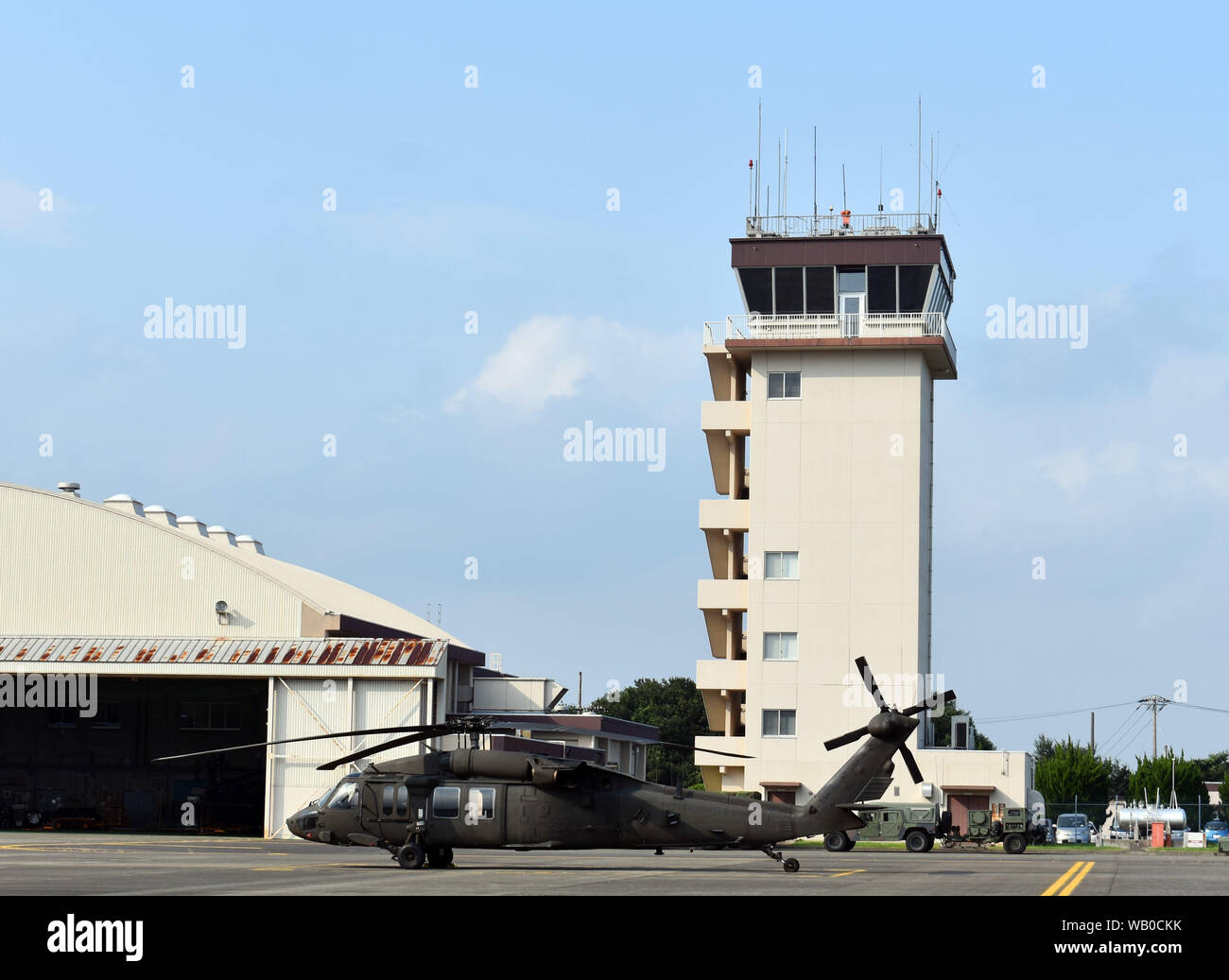 Ein Black Hawk Hubschrauber liegt neben der 120-Fuß-Air Traffic Control Tower bei Kastner Army im Camp Zama, Japan, August 19, 2019. Stockfoto
