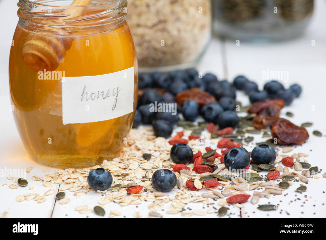 Krug Honig mit Beeren, Nüsse Samen und Hafer Stockfoto