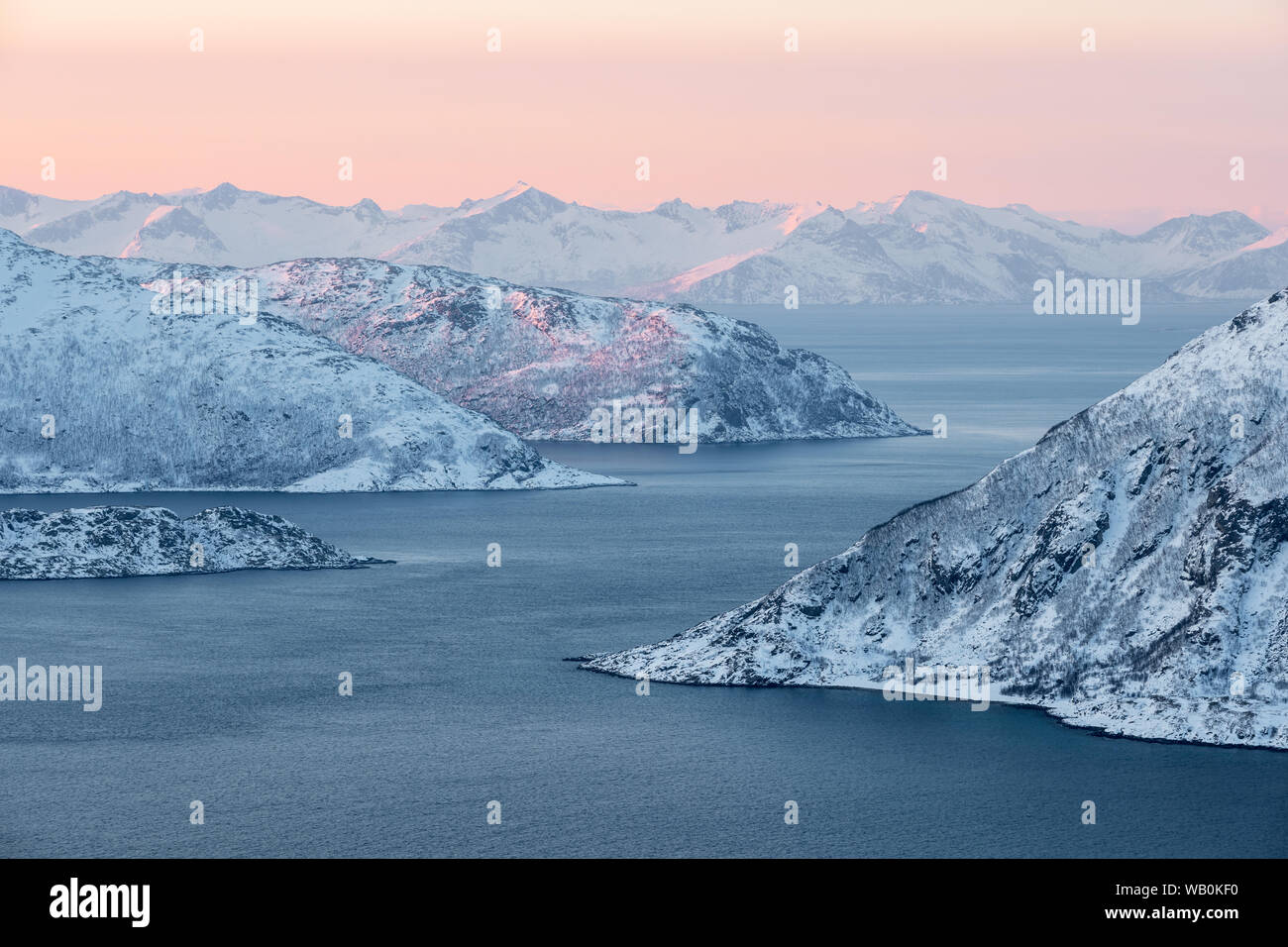 Arktische Landschaft: Fjord und schneebedeckten Bergen mit rot und orange Sunrise, Norwegen Stockfoto