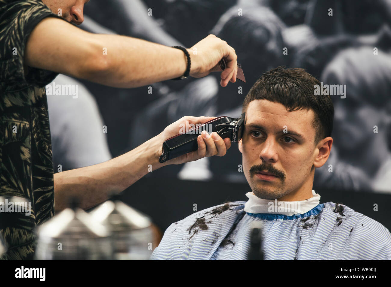 Schuss des Mannes immer trendigen Haarschnitt beim Friseur hautnah. Männliche Friseur servieren Kunden, was Haarschnitt mit Maschine und Kamm. Stockfoto
