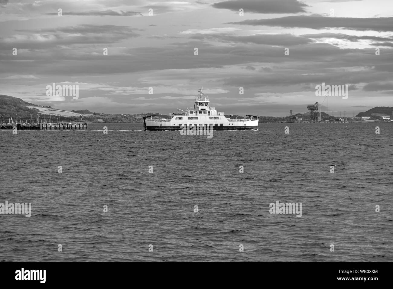 Largs Pier und die autofähre wie die Sonne geht hinter Cumbrae auf das Stadtzentrum und den Himmel reflektieren Stockfoto