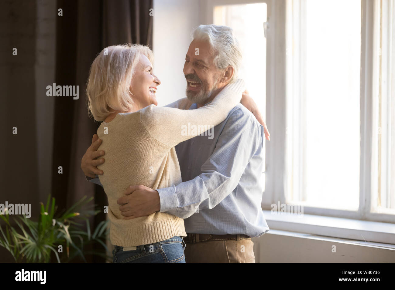 Gerne alte Pensionierte romantisches Paar tanzen im Wohnzimmer lachen Stockfoto