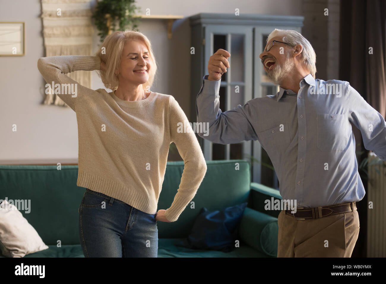 Gerne aktiv im Ruhestand ältere Paare tanzen zusammen im Wohnzimmer Stockfoto