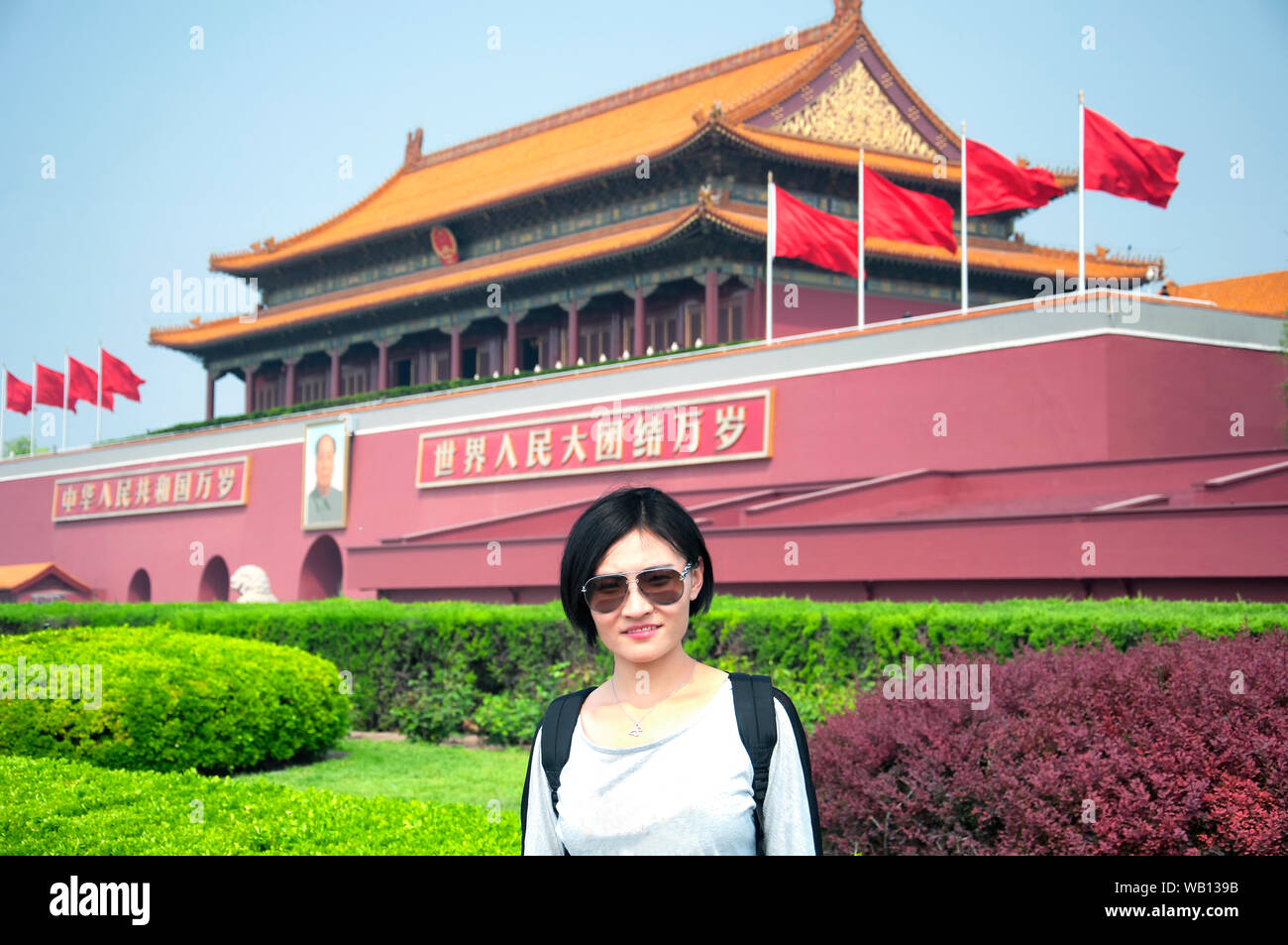 Eine chinesische Frau stand vor dem Eingang oder Tor der Harmonie der verbotenen Palast in Peking, China an einem sonnigen Tag. Chinesische Übersetzung ist t Stockfoto