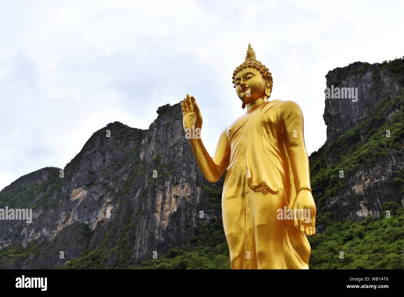 Die Haltung der verleitet, die Verwandten nicht Symbol der goldene Buddha Statue mit Berg Hintergrund zu streiten, Thailand Stockfoto
