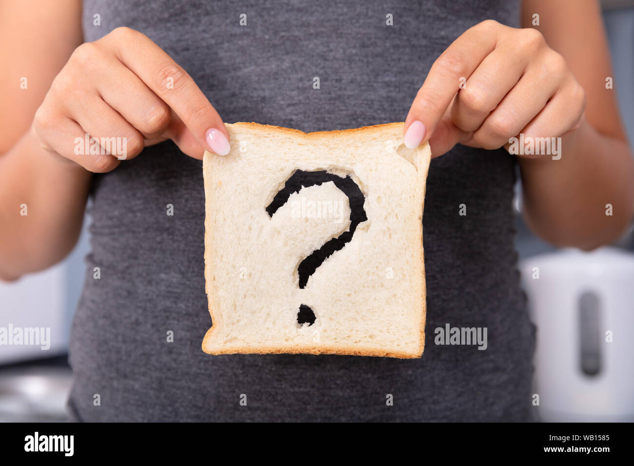 Im mittleren Abschnitt einer Frau Hände halten Geschnittenes Brot mit Fragezeichen Zeichen Stockfoto