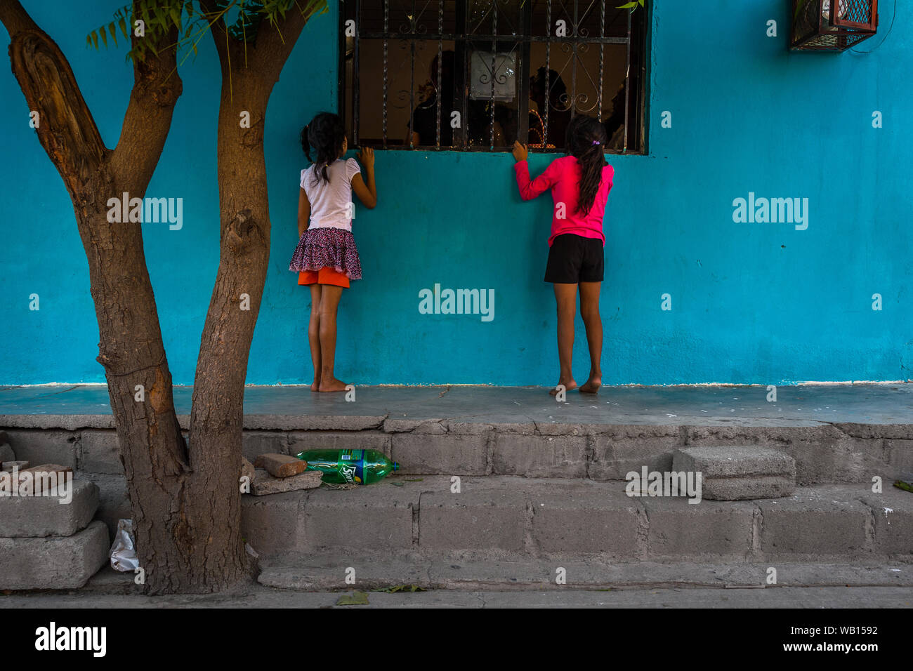 Mexikanische Mädchen Blick durch das Fenster zu einer "Muxe" (in der Regel, ein homosexueller Mann, der weiblichen Kleidung) Vorbereitung für das Festival in Mexiko sehen. Stockfoto