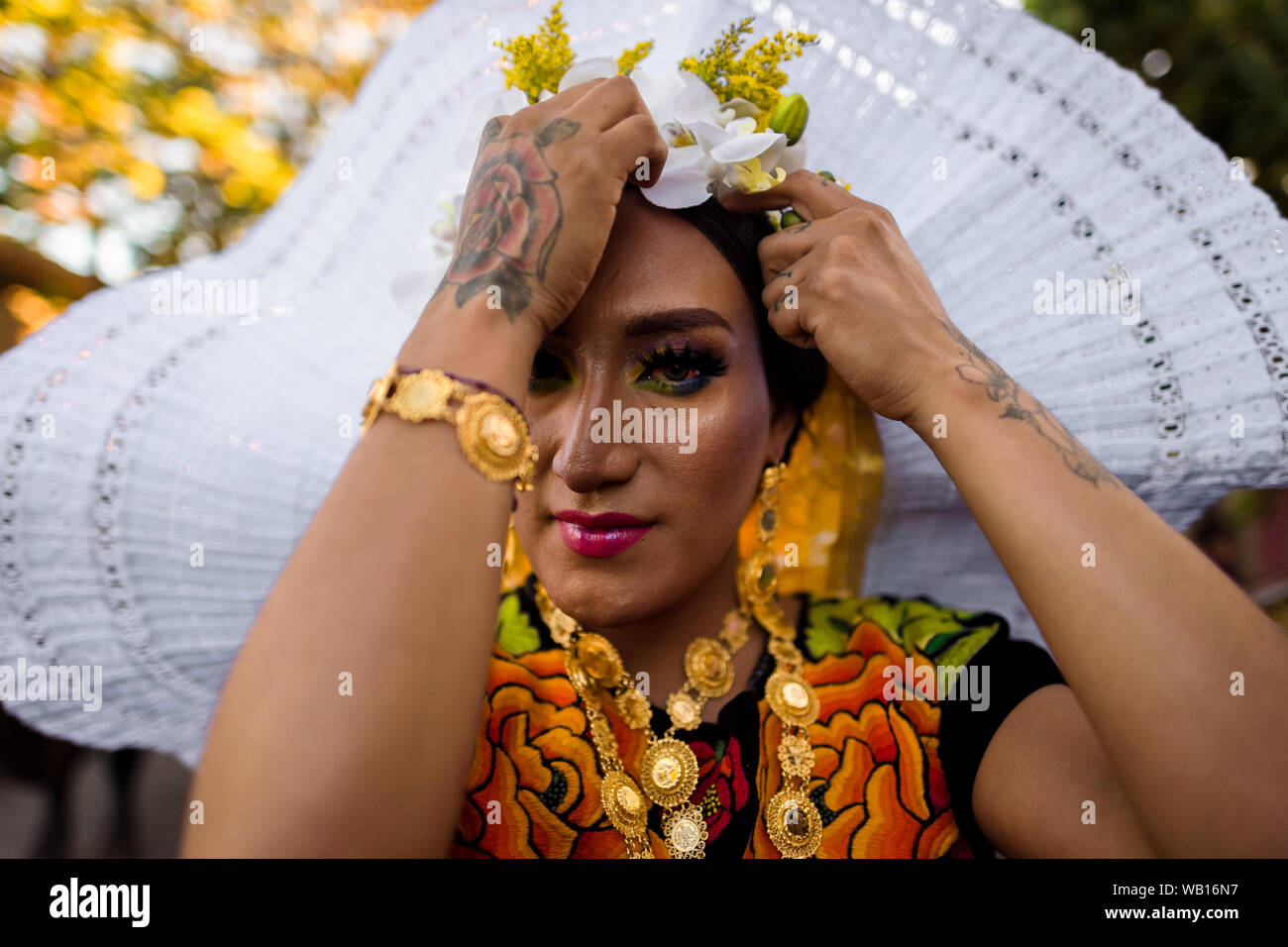 Eine Mexikanische "Muxe" (in der Regel, ein homosexueller Mann, der weiblichen Kleidung) stellt eine Kopfbedeckung während des Festivals in Juchitán de Zaragoza, Mexiko. Stockfoto