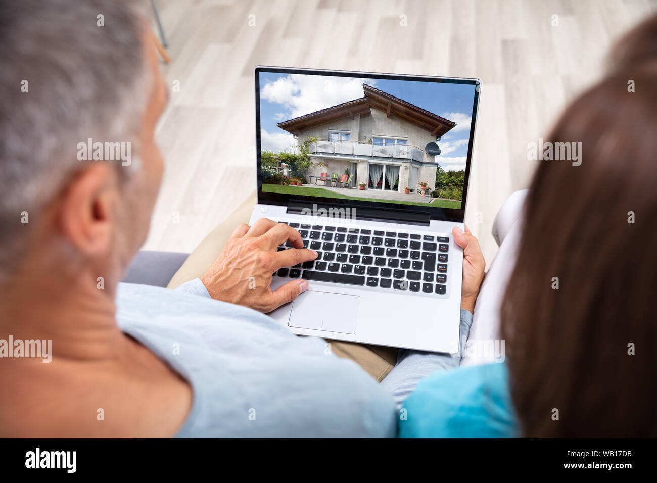 Paar an Haus Online auf Laptop zu Hause Suchen Stockfoto