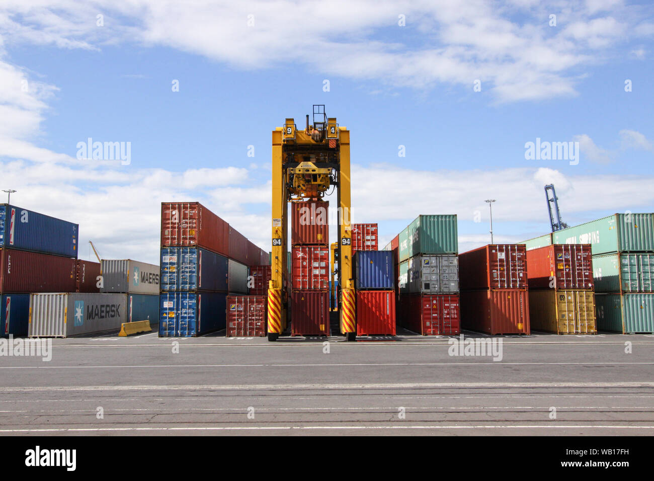 Straddle Carrier (Van Carrier) Anheben einen Container im Hafen von Auckland, Neuseeland Stockfoto