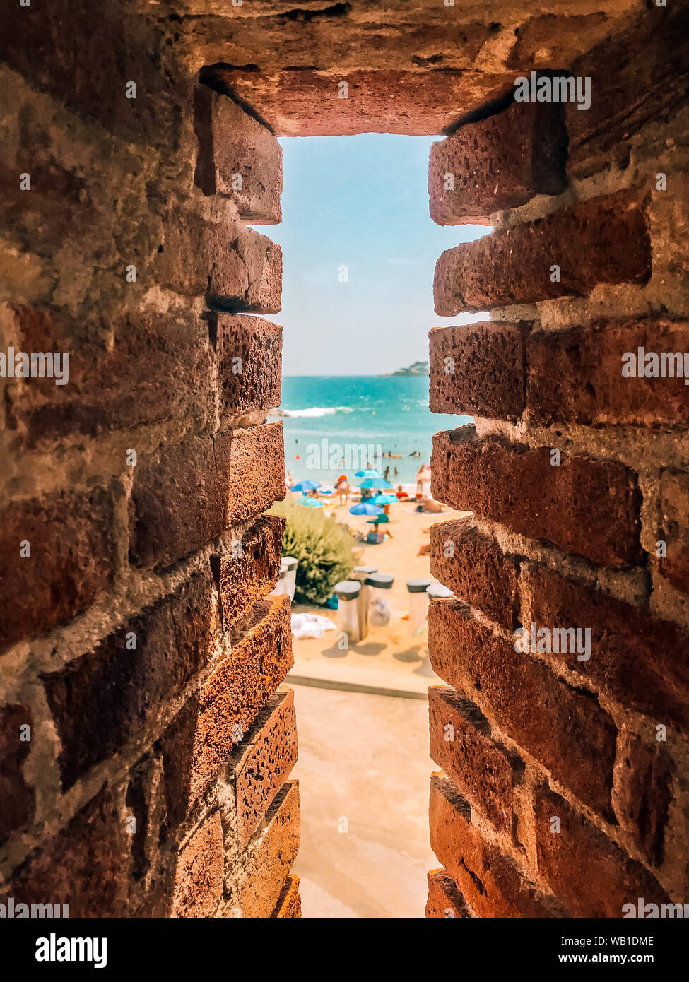 Sea Shore bech Blick durch alte Mauer tunnel Schlupfloch. Urlaub, Traum, Ruhe, Entspannung Sommer Konzept Stockfoto