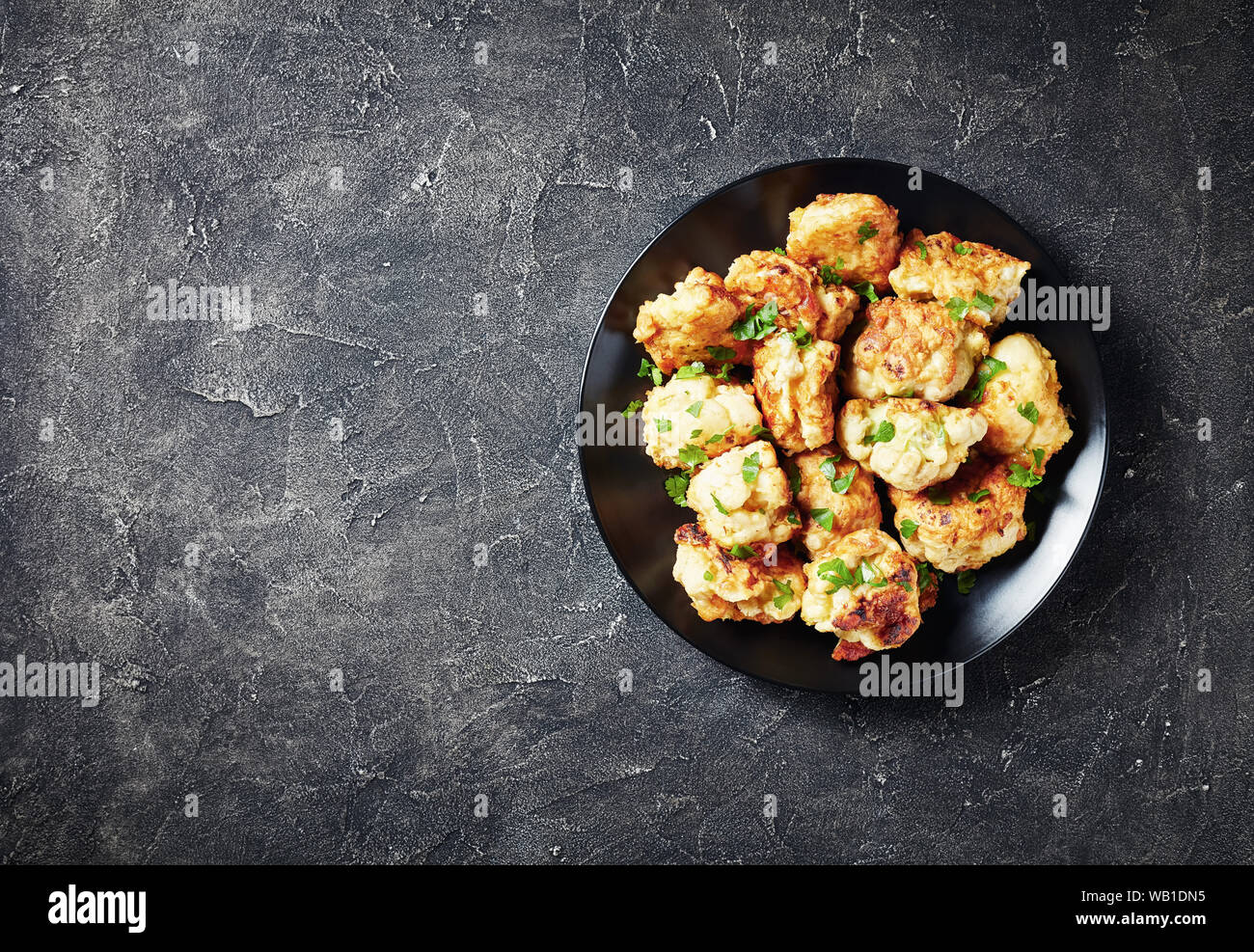 In Teig frittierte Blumenkohlröschen serviert auf einem schwarz auf grauem Beton Tabelle, Ansicht von oben, Nahaufnahme, flatlay, kopieren Raum Stockfoto